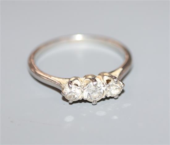 A mid 20th century platinum and three stone diamond ring, size L.